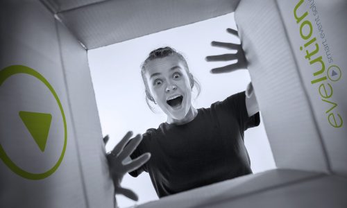 Girl looking into a cardbox and is suprised